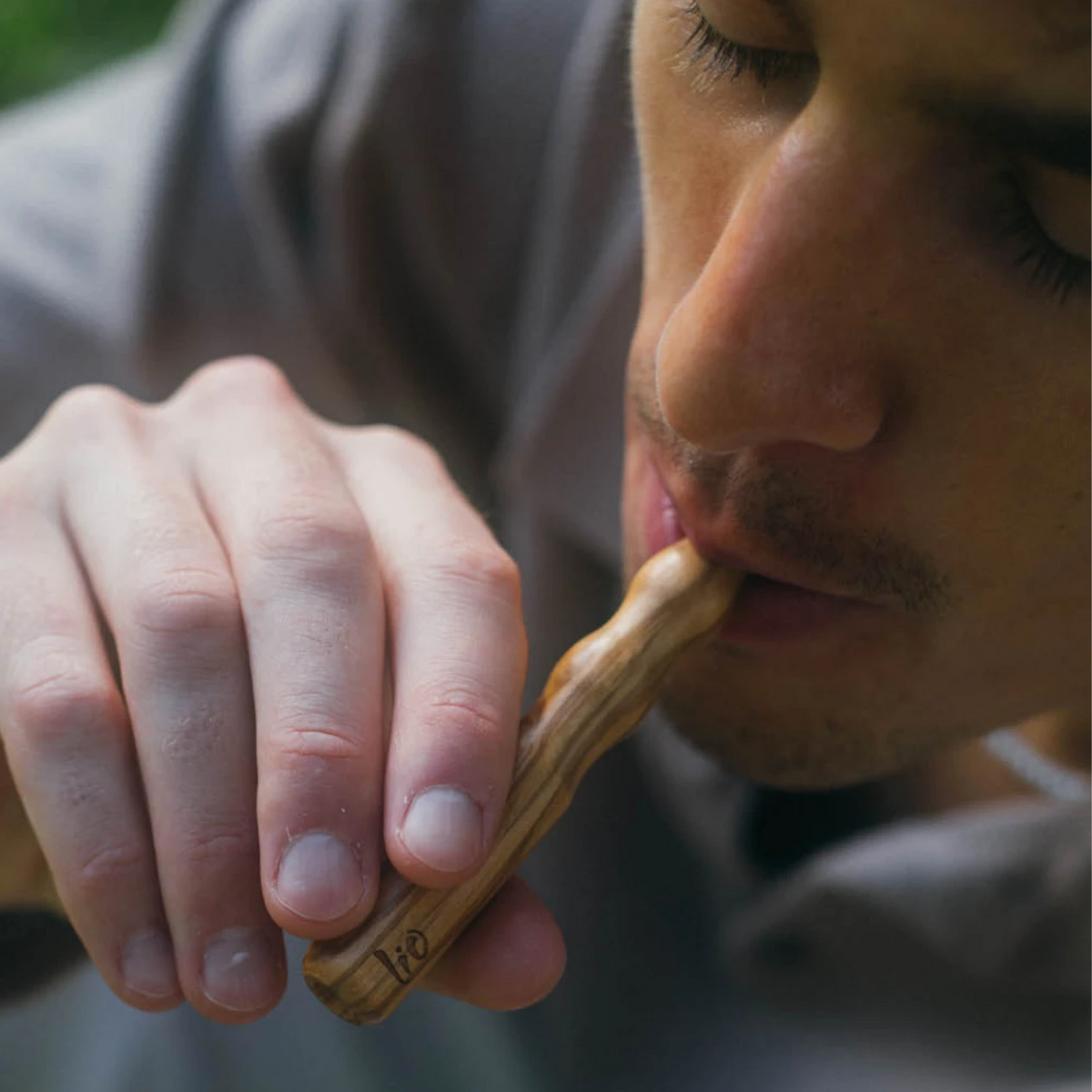 Man taking a draw from a Lio olive wood diffuser
